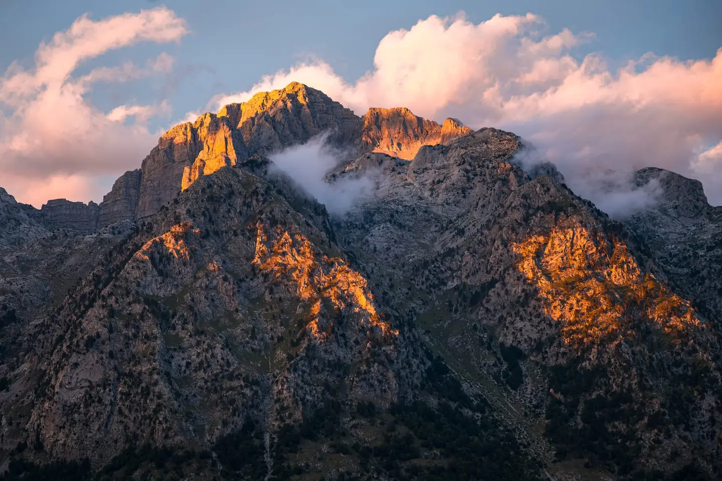 Warm last light rakes the jagged limestone summits of the Albanian Alps — the Prokletije, or Accursed Mountains — high above the Theth valley in northern Albania.
