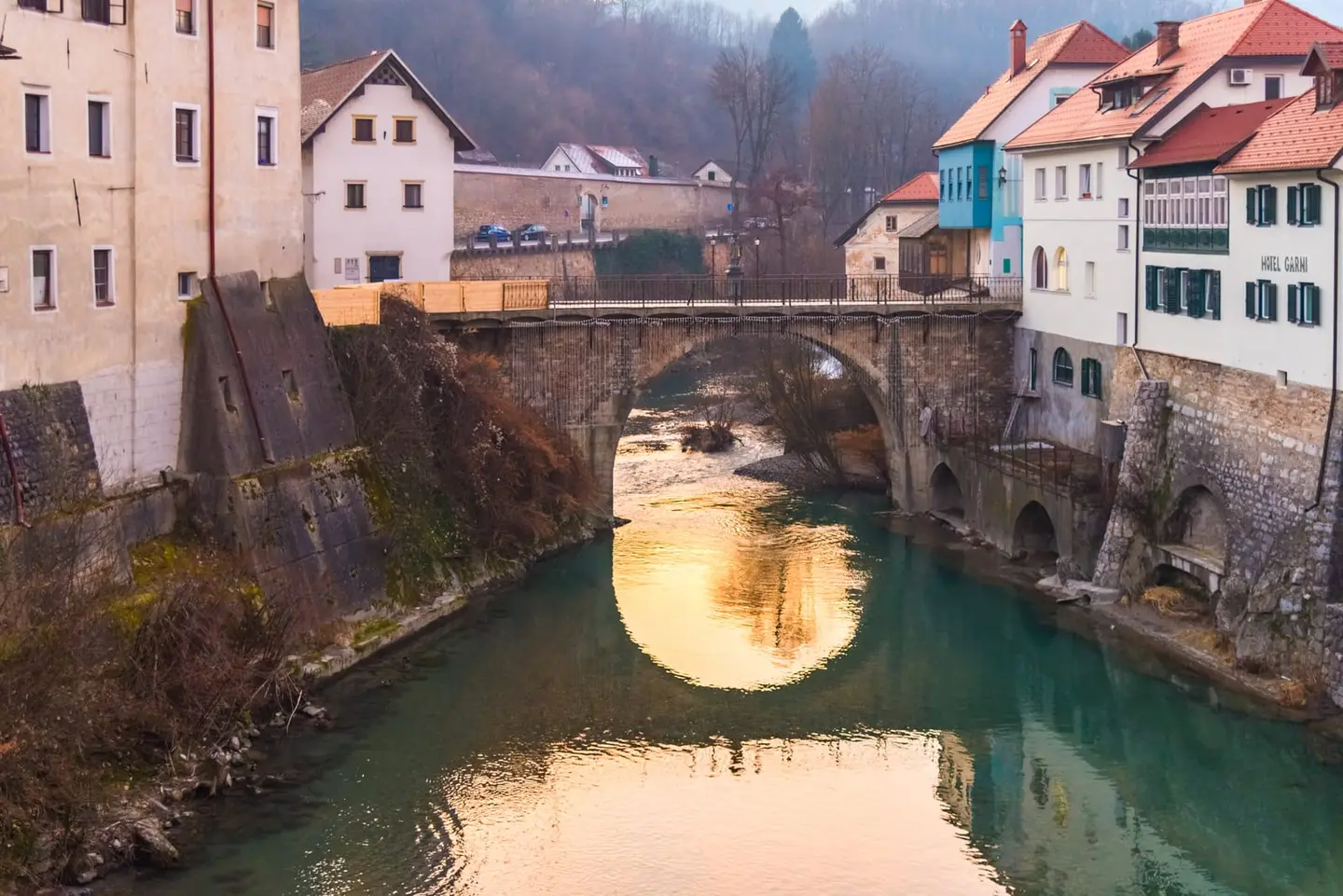 The medieval Kapucinijski most (Capuchin Bridge) arches over the emerald-green River Sora in Škofja Loka, a Slovenian hill town whose medieval core has been preserved almost intact since the 12th…